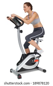 Side View Of A Beautiful Young Woman On Stationary Bike Over White Background