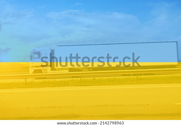 Side\
view of a big truck with a white trailer with space for text on a\
countryside road against a blue sky with a\
sunset