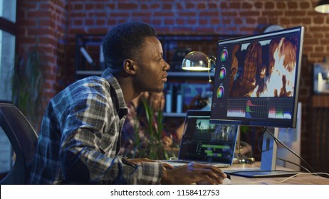 Side View Of Black Man Working On Computer And Editing Video With Color Correction