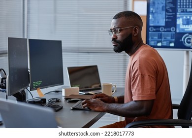 Side View Of Black Software Engineer Using Computer In High Technology Office, Data Systems And Programming