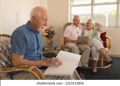 Side view of blind senior man reading a braille book while senior couple using digital tablet at nursing home - Powered by Shutterstock