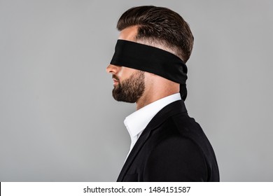 side view of blindfolded businessman in black suit isolated on grey