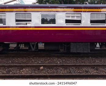 The side view of the bogie third class carriage of the ordinary train while stopping to pick up passengers at the train station, front view with the copy space.