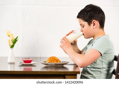 Side View Of Boy Drinking Milk During Breakfast