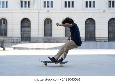 Side view of boy falling over his skateboard in the street. - Powered by Shutterstock