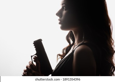 Side View Of Brunette Young Woman Holding Gun Isolated On White