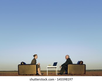 Side View Of Business People On Armchairs Communicating On Field