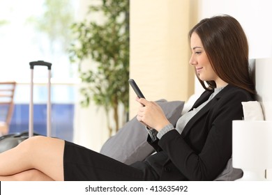 Side View Of A Businesswoman Texting On Phone In An Hotel Room During A Business Travel