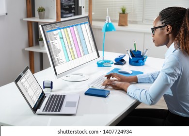 Side View Of Businesswoman's Hand Analyzing Data On Computer Over Desk