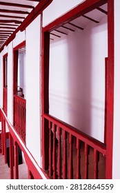 A side view capturing the verticality and depth of the theater's wooden galleries, showing the red railings, white walls, and structured framing.