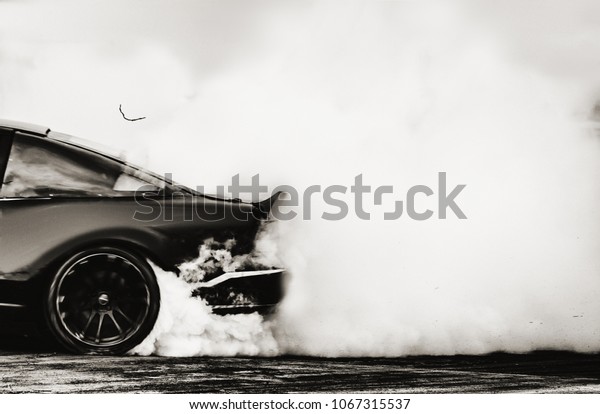Side view car drifting on track with\
grain, Sport car wheel drifting and smoking on track.\
