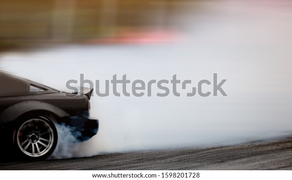 Side view car drifting on track with\
grain, Sport car wheel drifting and smoking on\
track.