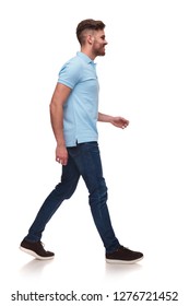 Side View Of Casual Man In Blue Polo Shirt Walking On White Background And Smiling, Full Body Picture