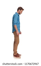 side view of a casual man looking down at something on white backgrouond