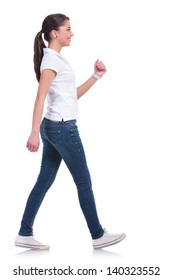 Side View Of A Casual Young Woman Walking Away From The Camera And Smiling. Isolated On White Background