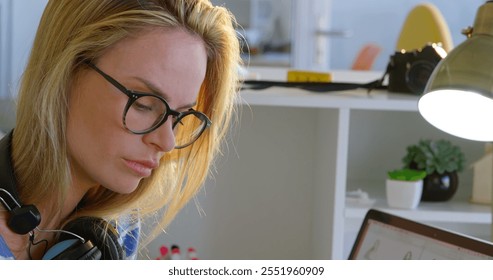 Side view of Caucasian female fashion designer using graphic tablet at desk in office. 4k - Powered by Shutterstock