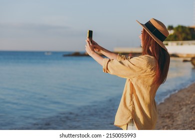 Side view caucasian young woman in straw hat shirt summer casual clothes take photo of landscape by mobile cell phone outdoors at sunrise sun over sea beach. People vacation lifestyle journey concept - Powered by Shutterstock