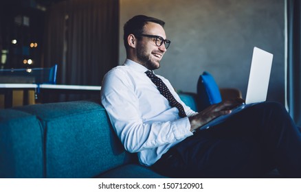 Side view of cheerful professional expert of business marketing reading positive received email from client using 4g connection on laptop computer, happy man in formal wear browsing web page - Shutterstock ID 1507120901