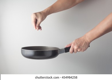 Side view of chef hand holding a frying pan preparing food. Cooking action concept