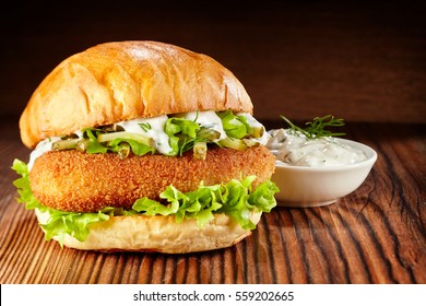 Side View Of Chicken Burger With Lettuce And Mayonnaise Dip On Wooden Table