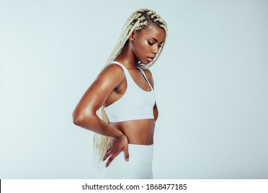 Side view close up of african american athletic woman on white background. Portrait of fitness woman with braided hair standing with hands on waist. - Powered by Shutterstock