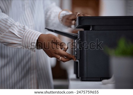 Side view close up on printer and female hands of office worker pressing button on multifunction laser printer in home office or at workplace. Student scanning documents at university, copy space