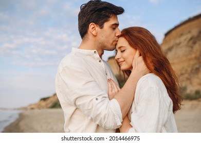 Side view close up smiling happy young lovely couple two friends family man woman in casual clothes hug each other kiss forehead at sunrise over sea beach outdoor seaside in summer day sunset evening.