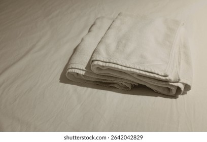 side view and close up a stack of white cleaning towel soft and fluffy,clean white,a on bed, ready for use in luxury modern hotel resort.