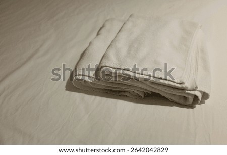 side view and close up a stack of white cleaning towel soft and fluffy,clean white,a on bed, ready for use in luxury modern hotel resort.