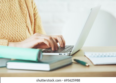 Side View And Close Up Of Woman Hands Typing On Laptop Keyboard Placed On Wooden Office Desktop With Supplies. Technology Concept 