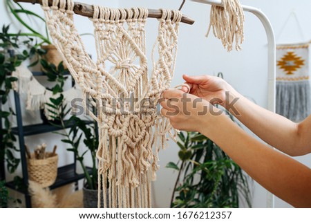 Side view, close-up of girl's hand at macrame weaving work