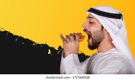 Side View Of Close-up Portrait Of Young Arab Man Eating A Burger. Hungry Arabic Guy Isolated On Black And Yellow Background Eating A Hamburger. Man Wearing Kandura And Ghutra Eating Junk Food.