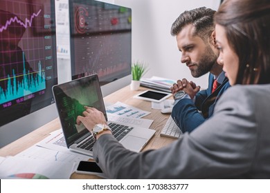 Side view of computer systems analysts using charts on computer monitors while working in office - Powered by Shutterstock