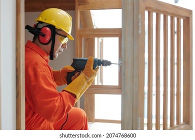 Side view of concentrated builder with drill using self-tapping screw when working with wood - Powered by Shutterstock