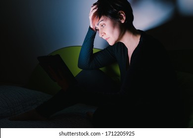 Side View Of Concerned European Woman Calling Friends With Tablet Device At Night. People Addicted To New Technologies. Stay Home Lifestyle. Social Distance Concept During Coronavirus Isolation.