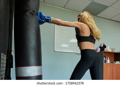 Side View Of Confident Female Boxer Exercising In Gym