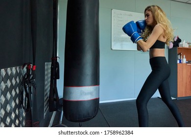 Side View Of Confident Female Boxer Exercising In Gym