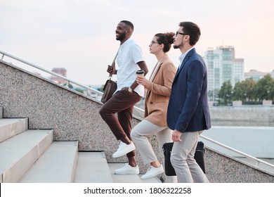 Side view of confident multi-ethnic students chatting and moving up stairs while walking into university - Powered by Shutterstock