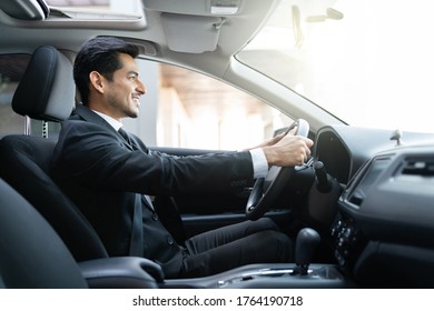 Side View Of Confident Young Businessman Driving Car In City