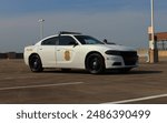 a side view of a cop car on top of a parking garage.