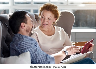 Side View Of Couple Using Laptop On Couch