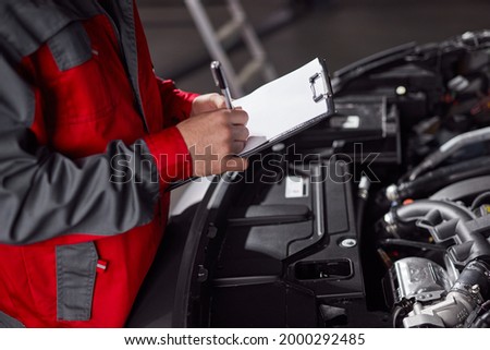 Similar – Image, Stock Photo Anonymous repairman examining car exhaust system in garage