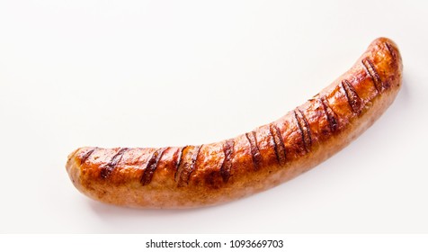 Side view of curved single German bratwurst sausage on white background.