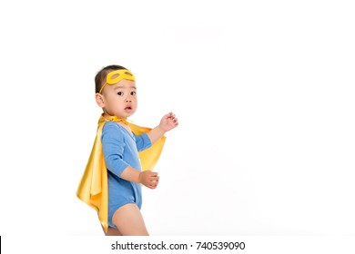 Side View Of Cute Asian Toddler Boy In Superhero Costume Isolated On White