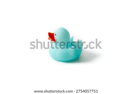Side view of a cute light blue rubber duck toy isolated on white background with soft shadow. Profile shot of a blue plastic duckling with orange beak, minimalist studio photography on white.