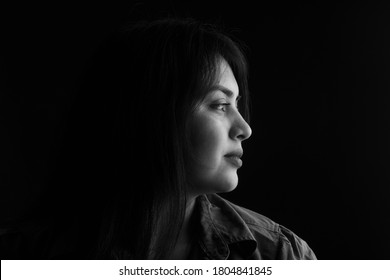 Side View Of Dark Portrait Of A Latin Woman On Black Background, Black And White