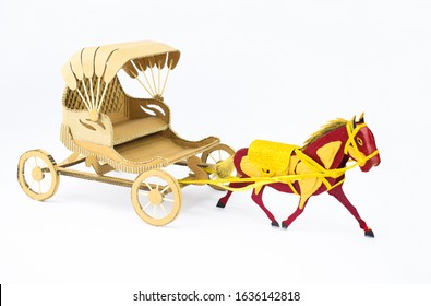 Side View Of A Decorated Horse Made Of Cardboard Pulling A Cardboard Carriage On A White Background