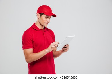 Side view of delivery man with tablet. isolated gray background