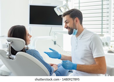 Side View Of Dentist Advicing And Gesturing To Patient In Modern Clinic