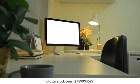 Side view desktop computer mockup on office desk with lamp and night lighting.